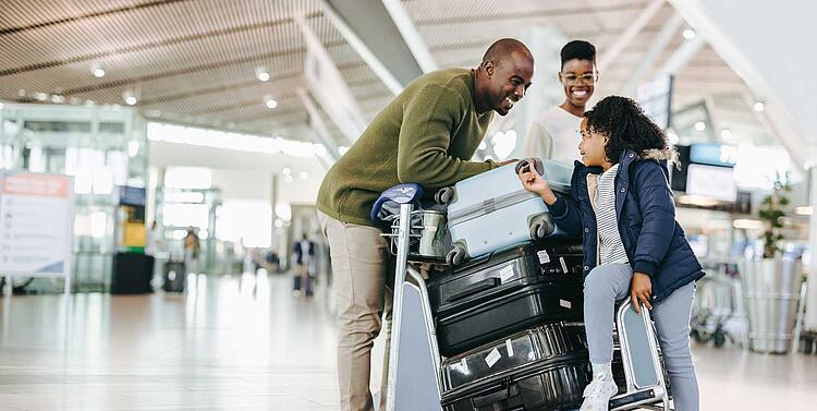 Familie mit Koffern am Flughafen
