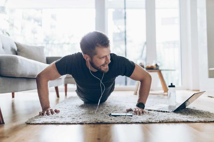 Mann beim Workout zu Hause im Wohnzimmer