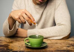 Mann gibt Zucker in eine Tasse