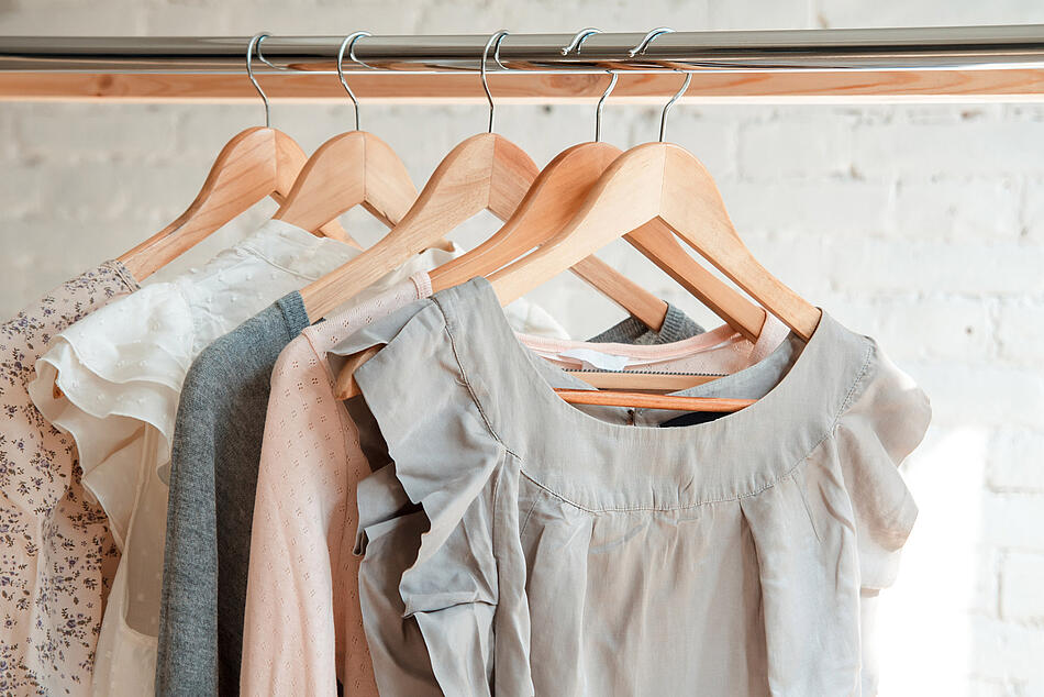 Damenkleidung hängt auf Bügeln im Kleiderschrank.