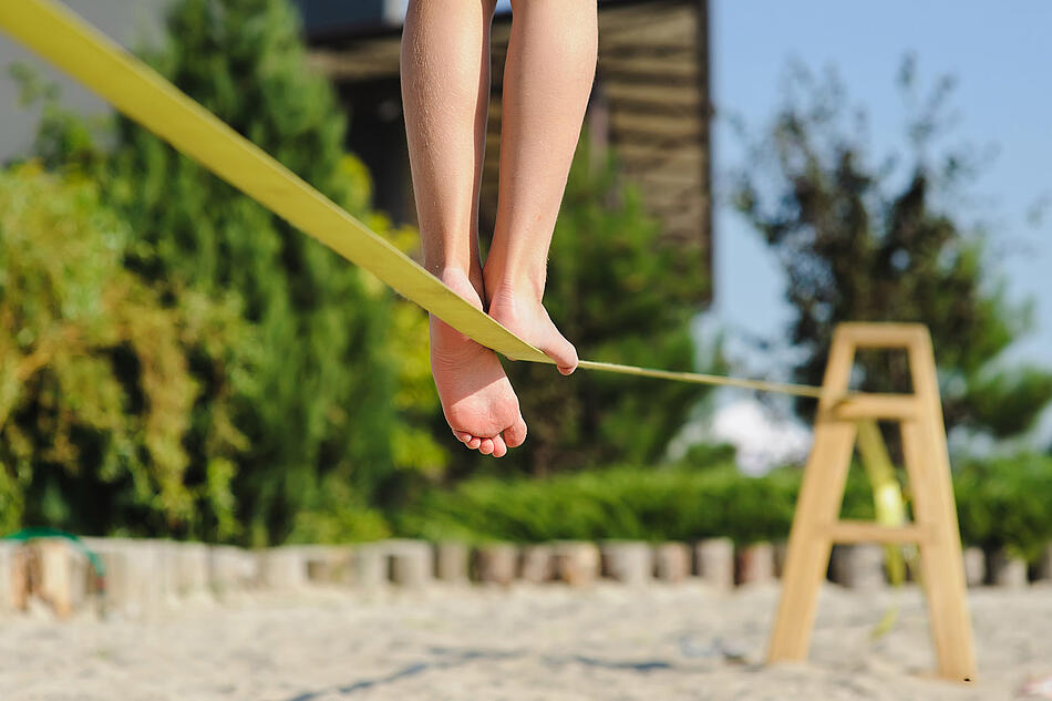 Füße auf einer Slackline.