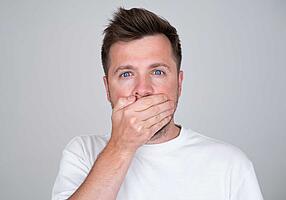 Mundgeruch – Mann hält sich die Hand vor den Mund