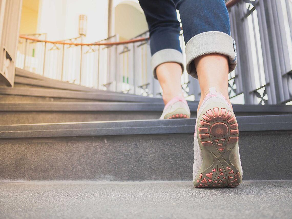 Frauenbeine steigen eine Treppe hoch.