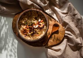Porridge mit Mandeln, Pistazien und Nüssen in einer Kokosnussschale