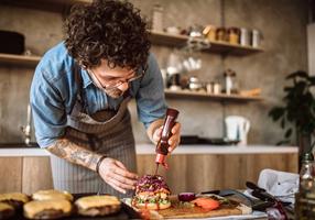 Mann macht Ketchup auf einen Burger