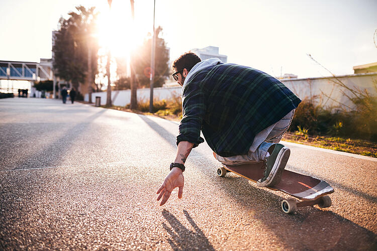 Junger Mann auf einem Longboard.