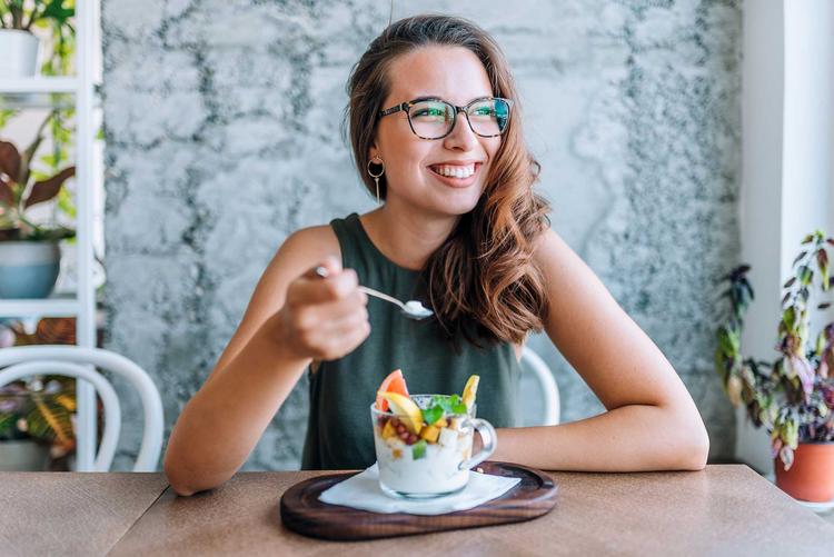 Junge Frau isst einen Fruchtsalat