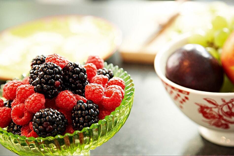 Zwei Schüsseln mit Beeren und Früchten.