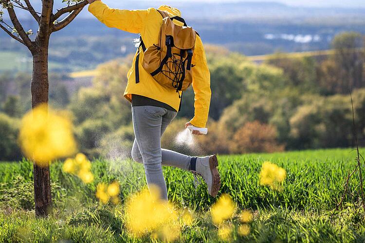 Wanderer benutzt Zeckenspray.