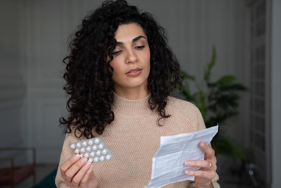 Frau liest den Beipackzettel eines Medikamentes