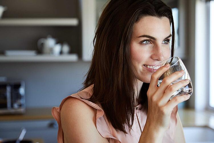 Frau trinkt ein Glas Wasser