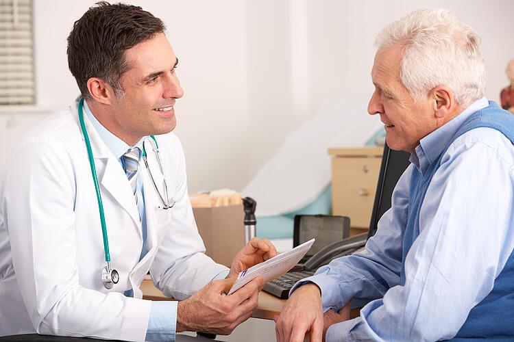 Arzt im Gespräch mit älterem Patient