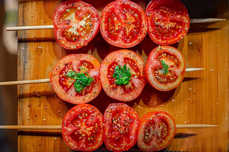 Grilltomaten – gewürzte Tomatenscheiben auf einem Holzspiess