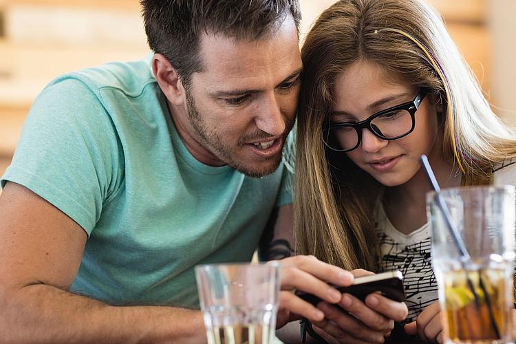 Bildnachweis: © wdv / Jan Lauer Vater und Tochter schauen gemeinsam auf ein Smartphone.