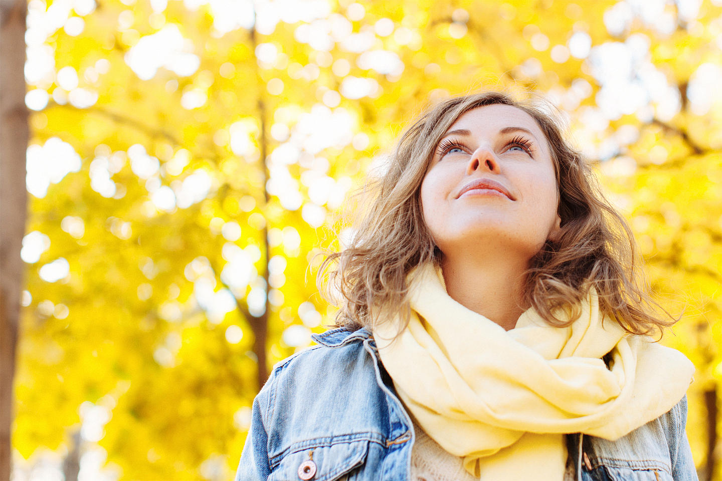 Frau vor Bäumen mit Herbstlaub. - Bildnachweis: © istockphoto.com / 5ugarless Frau vor Bäumen mit Herbstlaub.