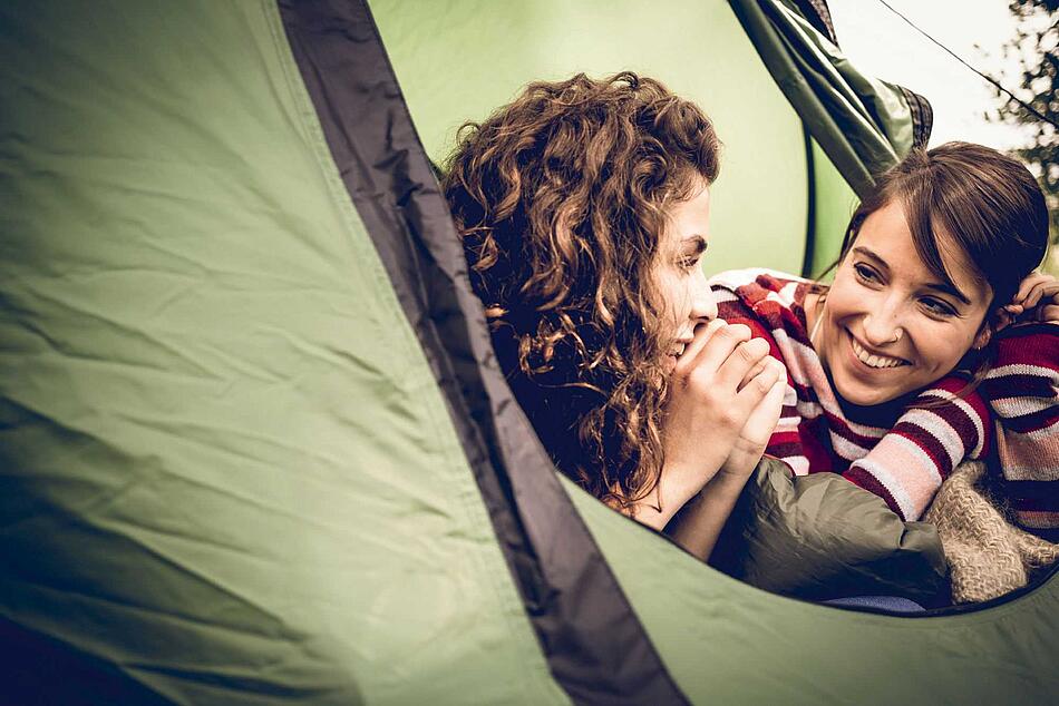 Zwei Mädchen liegen im Zelt
