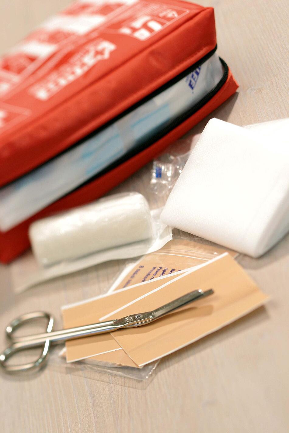 Erste Hilfe Tasche mit Verbandmaterial, Pflaster und Schere.
