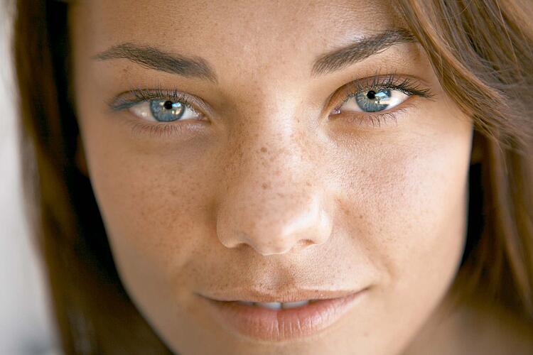 Gesicht einer jungen Frau mit blauen Augen.