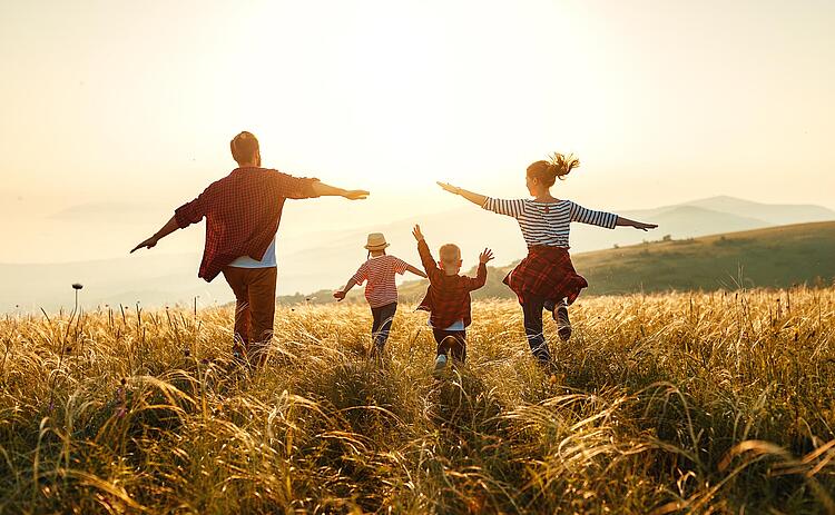 Familie läuft über eine Wiese