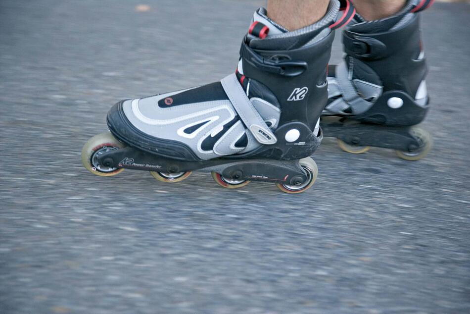 Inlineskating, Ausschnitt Füße auf Asphalt.