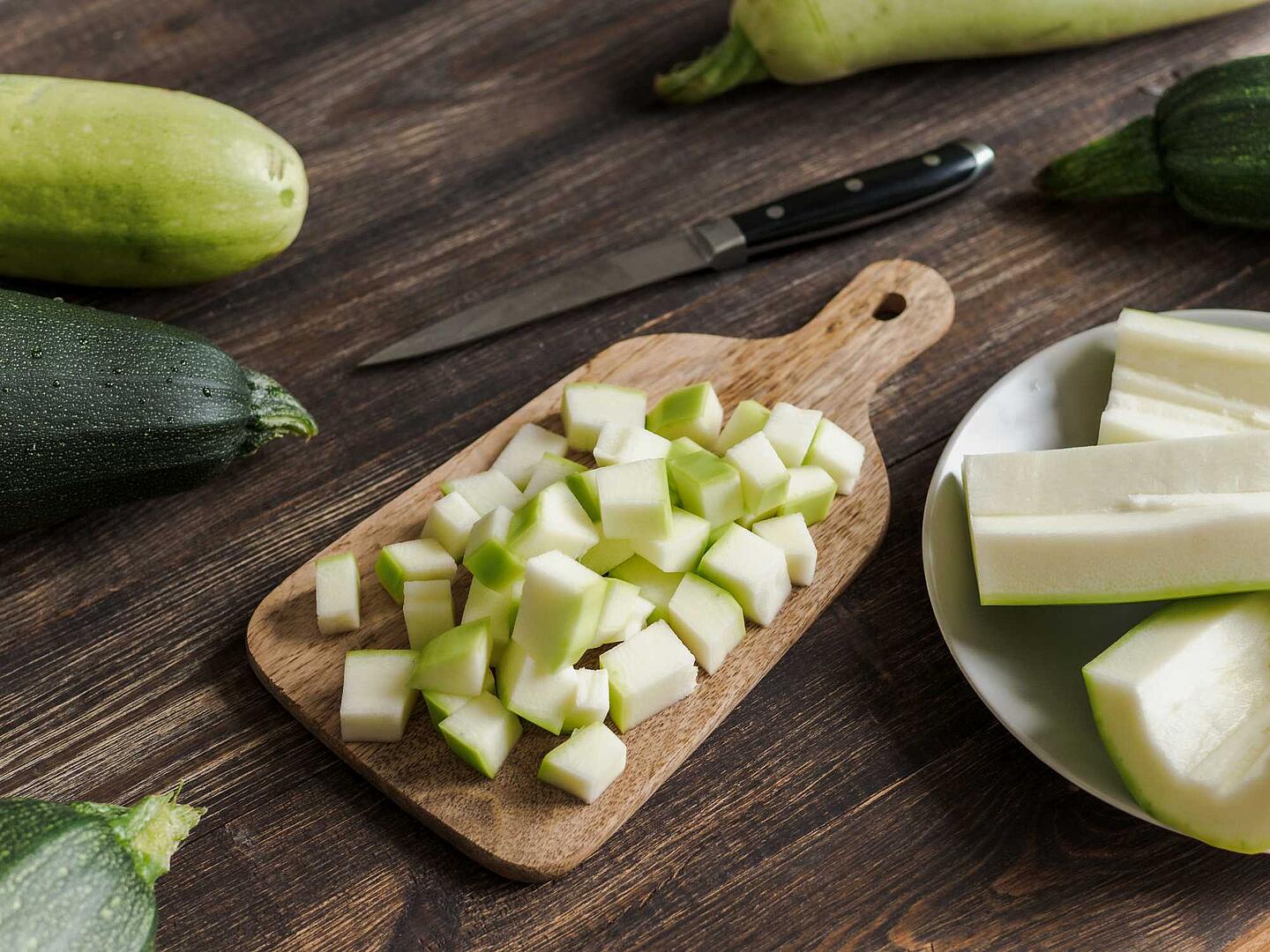 Zucchiniwürfel auf einem Holzbrett