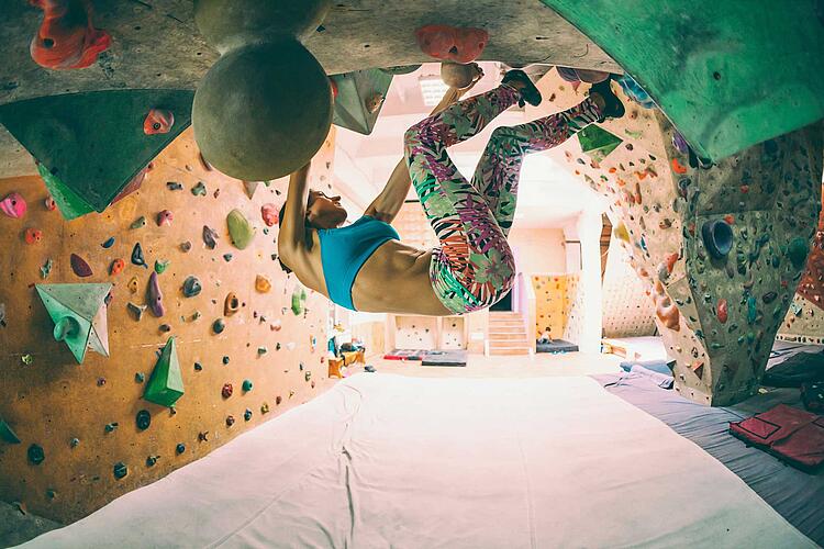 Bouldern: Frau in der Kletterhalle