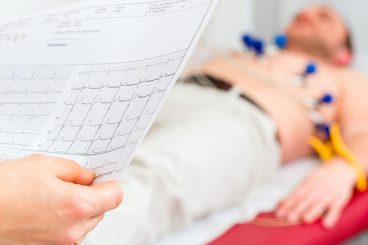 Arzt sieht sich das EKG eines Patienten an