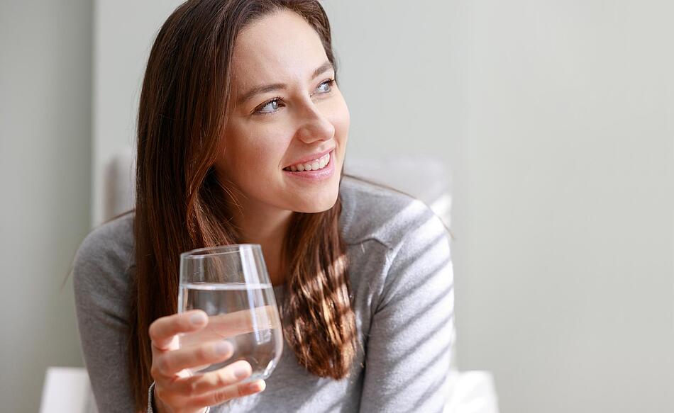 Frau hält ein Glas Wasser in der Hand