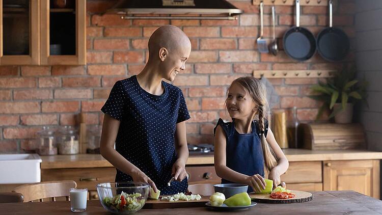 Krebskranke Mutter kocht mit ihrer Tochter.