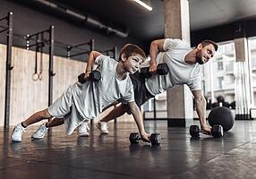 Krafttraining für Kinder: Vater und Sohn trainieren im Fitnessstudio