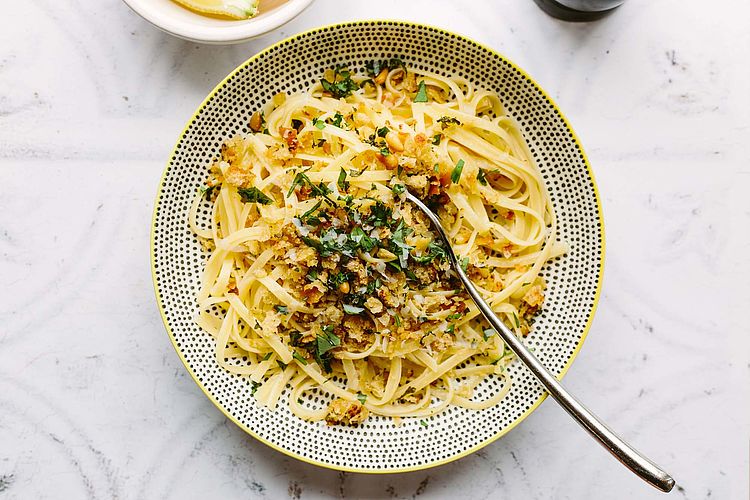 Bildnachweis: © stocksy.com / Helen Rushbrook Linguine mit Walnüssen und Lachs auf einem Teller angerichtet.