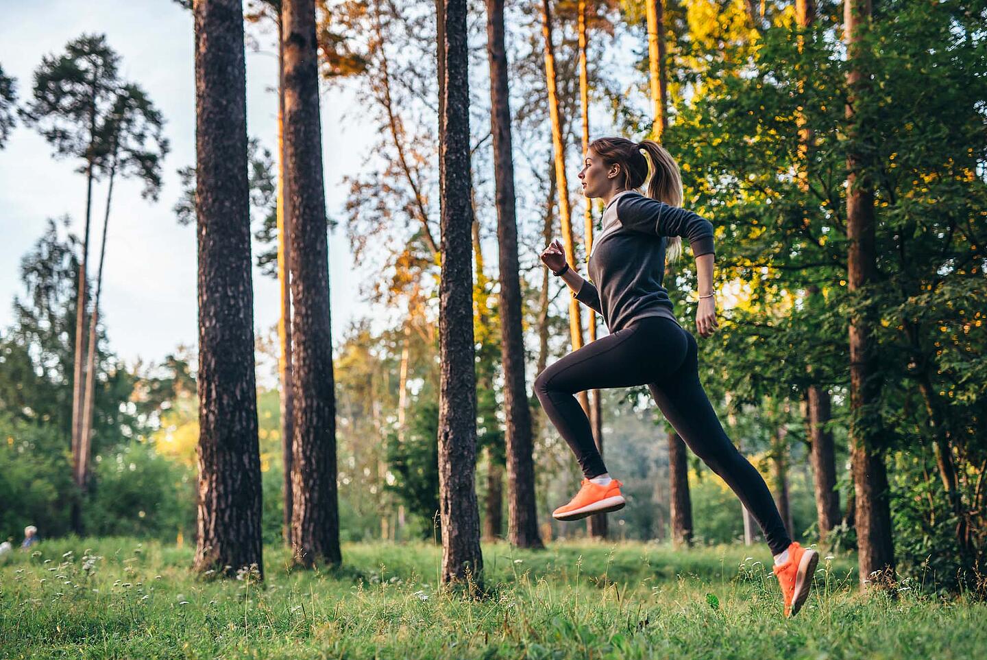 Junge Frau joggt im Wald.