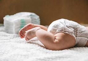 Baby mit Windelpo liegt auf dem Bauch