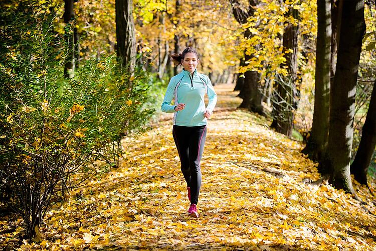 Frau joggt in herbstlicher Natur
