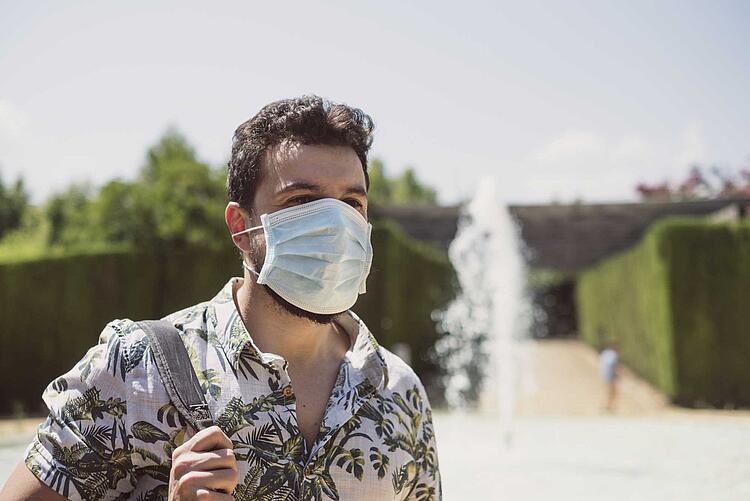 Mann trägt Maske im Sommer im Park