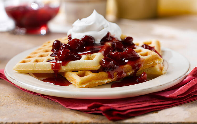 Waffeln mit Kirschen und Schlagsahne.