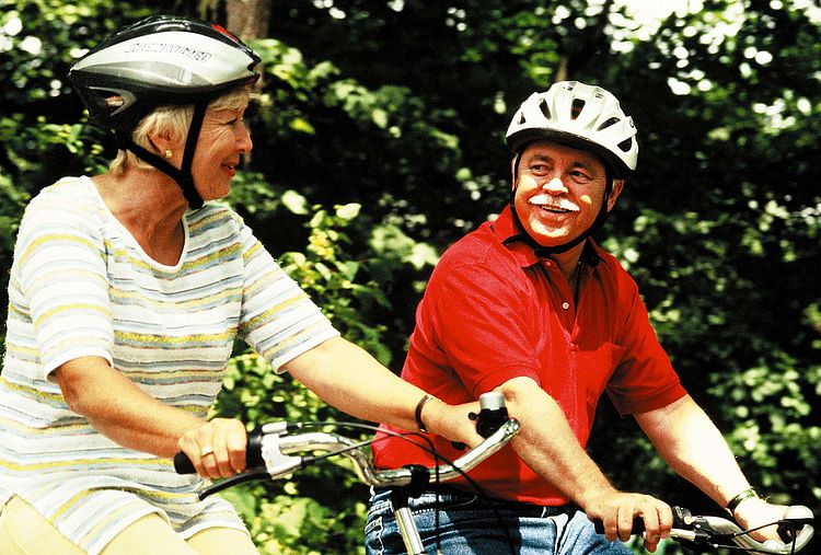 Älteres Paar mit Fahrradhelmen beim Radfahren im Wald. - Bildnachweis: © wdv / Jan Lauer Älteres Paar mit Fahrradhelmen beim Radfahren im Wald.