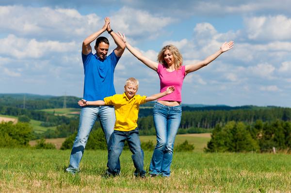 Familie spielt auf einer Wiese Hampelmann