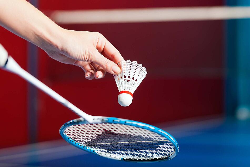 Hand mit Badmintonschläger.