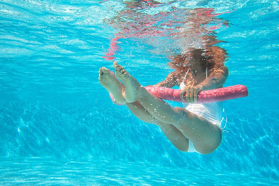 Unterwasseraufnahme einer Frau die Wassergymnastik macht