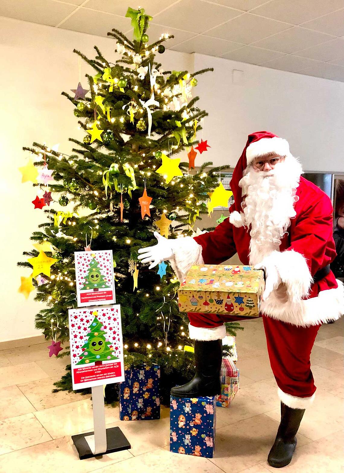 Weihnachtsmann Andreas Vogt vor einem geschmückten Tannenbaum