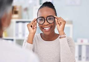 Junge Frau setzt eine Brille auf