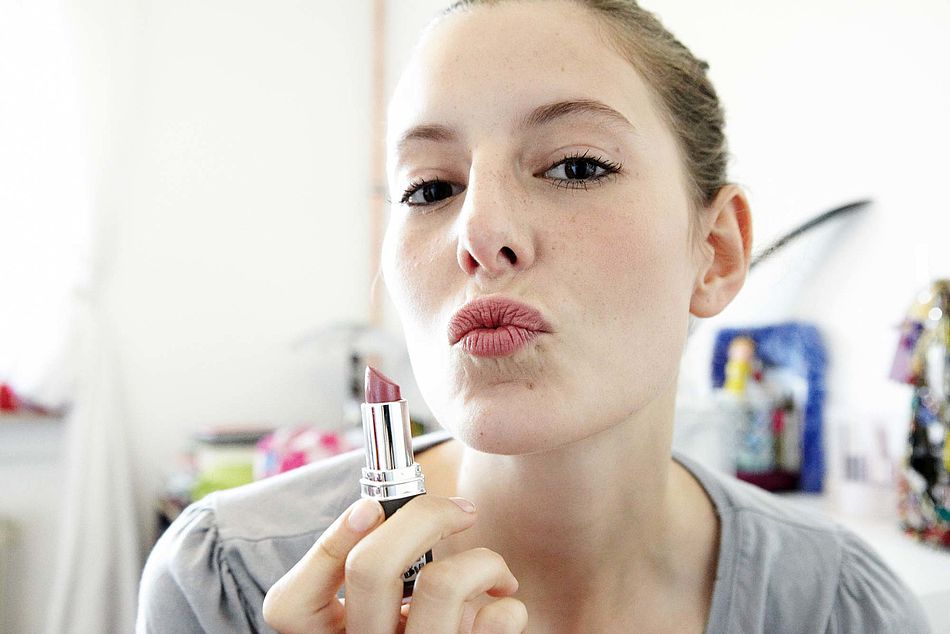 Eine Jugendliche mit einem Lippenstift in der Hand macht einen Kussmund. - Bildnachweis: © wdv / Oana Szekely Eine Jugendliche mit einem Lippenstift in der Hand macht einen Kussmund.