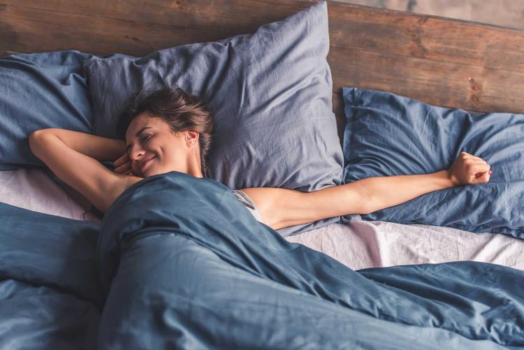 Bildnachweis: © stock.adobe.com / georgerudy Frau streckt sich im Bett