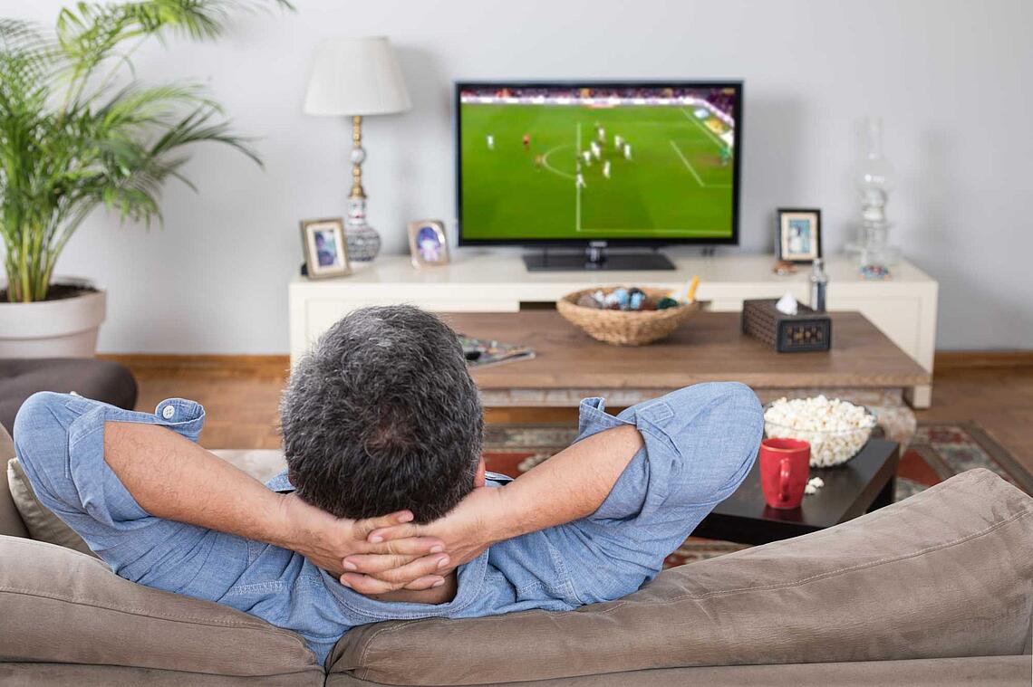 Mann schaut Fußball im Fernsehen