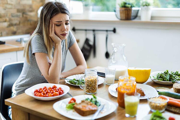 Frau sitzt vor ihrem Frühstück und will nichts essen