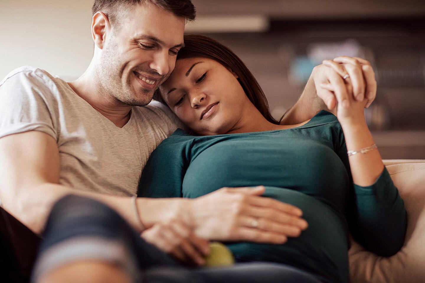 Mann streichelt Bauch einer Schwangeren