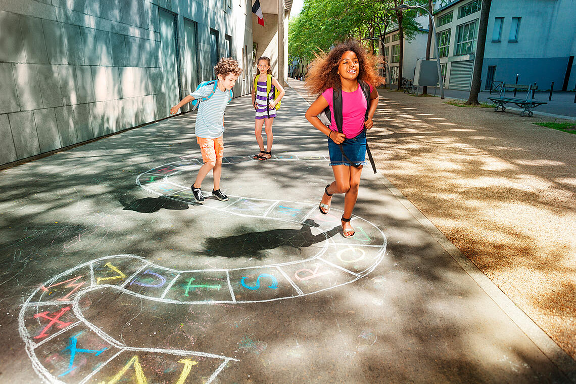 Kinder spielen Hüpfkästchen