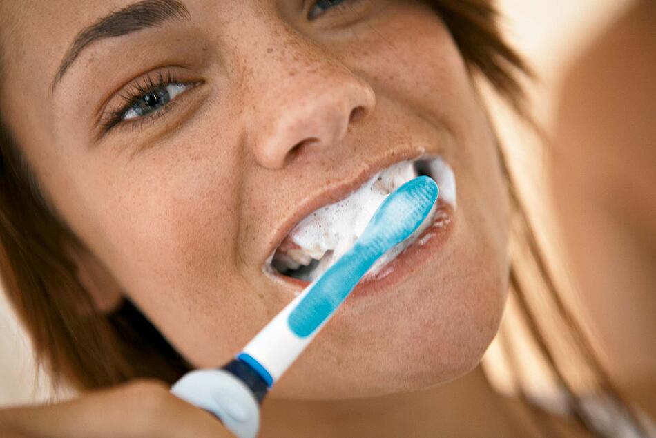 Junge Frau putzt sich die Zähne.