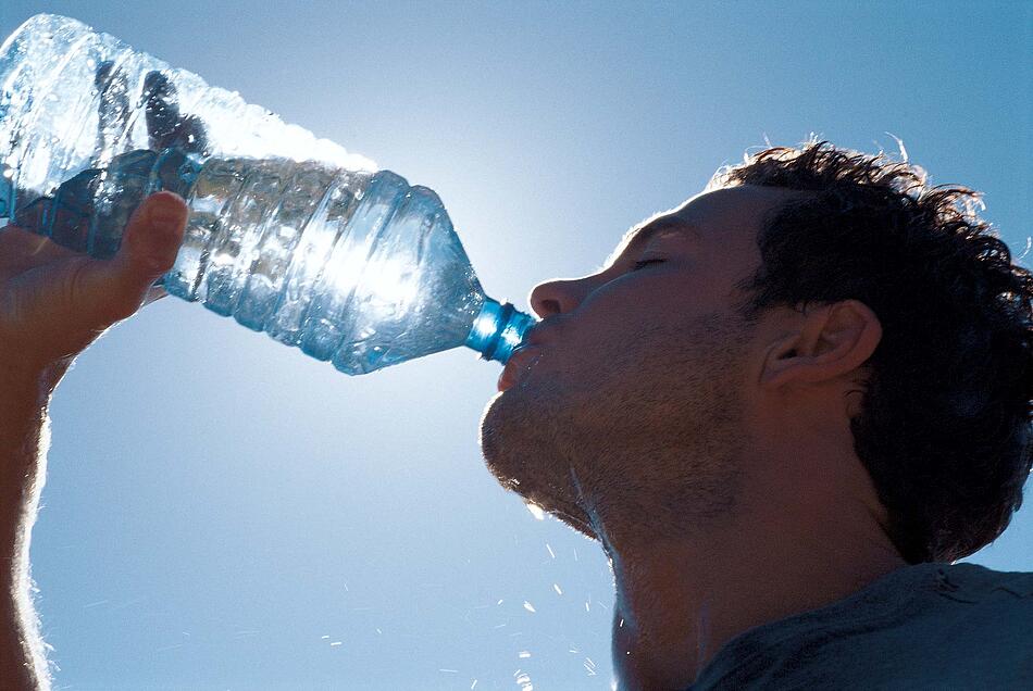 Mann trinkt aus einer Wasserflasche.